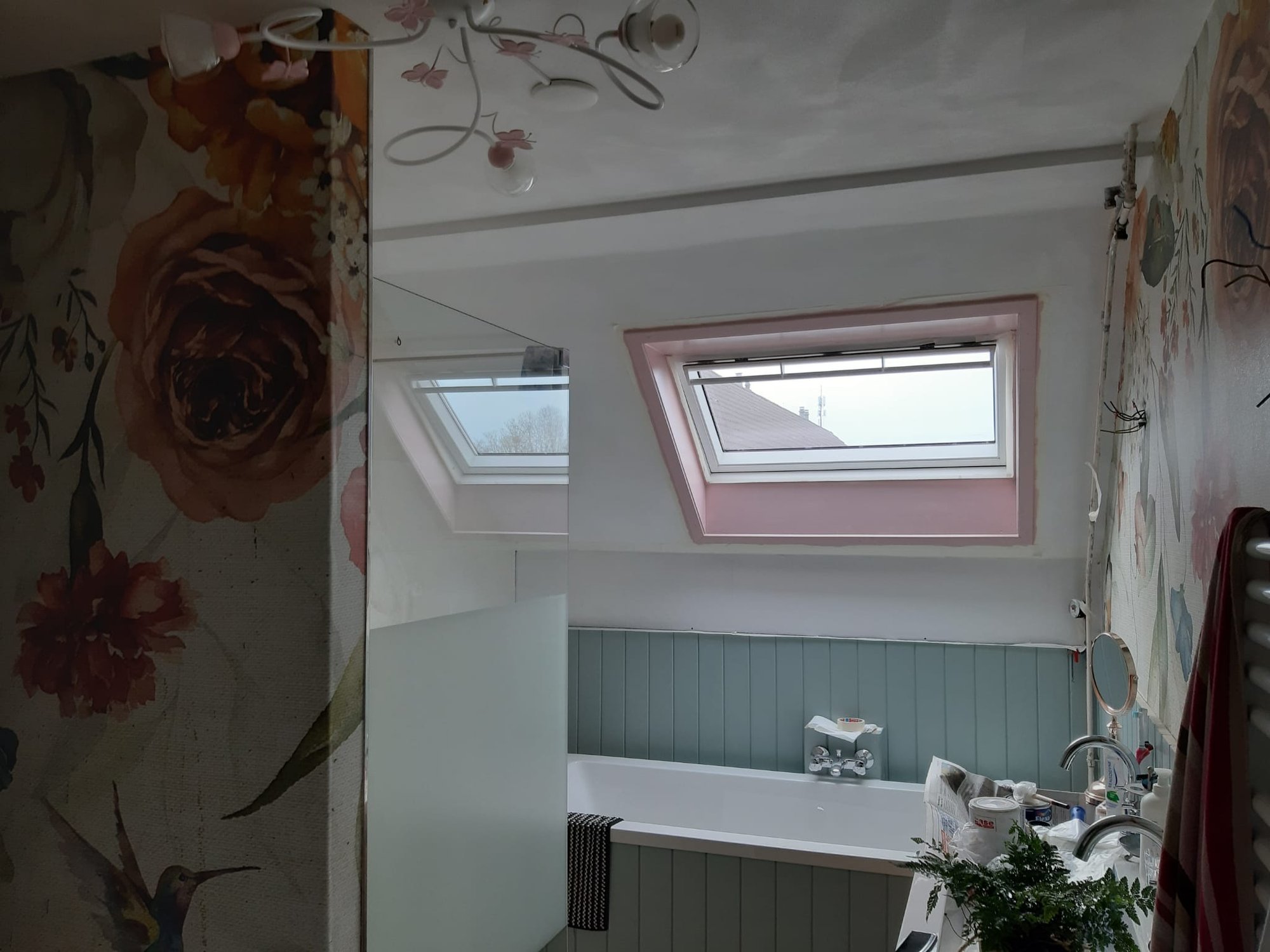 Dakraam met spiegel en bloemenbehang in de gerenoveerde badkamer in Britse stijl in Hoogezand